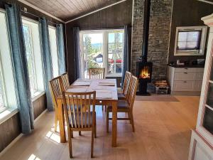 une salle à manger avec une table, des chaises et une cheminée dans l'établissement 11 person holiday home in Osen, à Vika