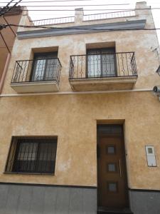 - un bâtiment avec deux fenêtres, une porte et un balcon dans l'établissement Casa de Xerta, à Xerta