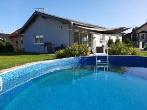 uma piscina azul em frente a uma casa em apartmán Ela em Skalná