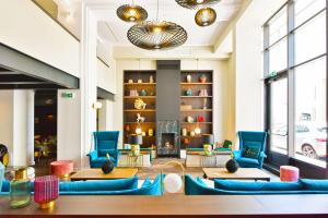 a lobby with blue chairs and a fireplace at Hôtel La Villa Port d'Antibes & Spa in Antibes