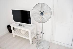 ein weißes Zimmer mit einem weißen Ventilator neben einem TV in der Unterkunft Old Charming House Faro in Faro