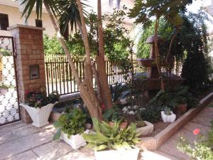 un jardín con plantas, una valla y un árbol en Villa Cavaliere, en Altino