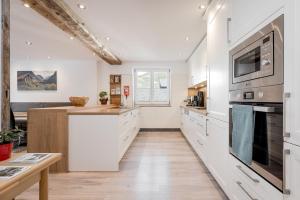 Haus Isabella Apartments - Oetz في أوتز: مطبخ بدولاب بيضاء وقمة كونتر