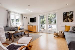 Haus Isabella Apartments - Oetz في أوتز: غرفة معيشة مع أريكة وطاولة