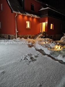 uma casa com neve no chão em frente dela em Wiesenblick em Dönschten