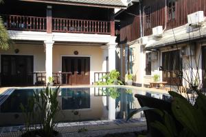 a villa with a swimming pool in front of a house at Alana Luang Prabang in Luang Prabang