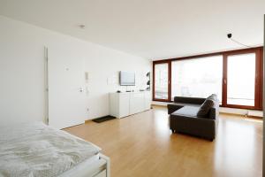 a white room with a bed and a couch at Stylisches Penthouse in Karlsruhe -Durlach in Karlsruhe