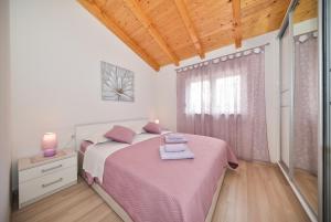 a bedroom with a bed with pink sheets and a window at Apartment Irena in Posedarje