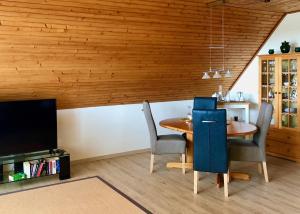 a dining room with a wooden ceiling and a table and chairs at Ferienwohnung Bolle in Hooksiel