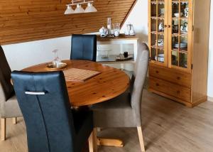 a wooden table with chairs and a dining room at Ferienwohnung Bolle in Hooksiel