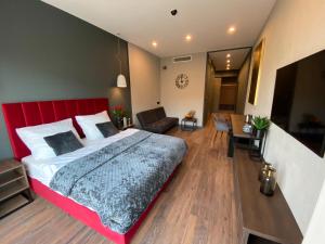 a bedroom with a large bed with a red headboard at Aparts Hotel Radom in Radom
