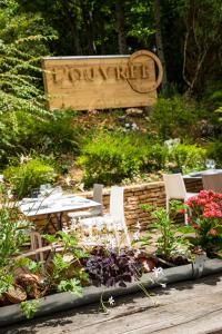 einen Garten mit Stühlen und Blumen vor einem Schild in der Unterkunft Hôtel L'Ouvrée in Savigny-lès-Beaune