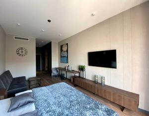 a bedroom with a large bed and a flat screen tv at Aparts Hotel Radom in Radom