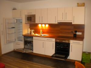 een keuken met witte kasten en een wastafel bij Appartement Andi in Wagrain