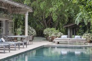 a backyard with a pool with chairs and a table at Balquisse Heritage Hotel in Jimbaran