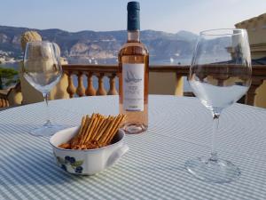 a table with a bottle of wine and two wine glasses at Hôtel de Charme Brise Marine in Saint-Jean-Cap-Ferrat