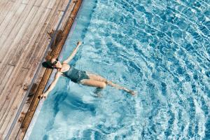 Eine Frau, die im Schwimmbad schwimmt. in der Unterkunft Boutique Hotel Das Rivus in Leogang