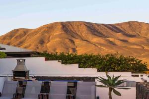 a building with a mountain in the background at Villa Pola Marinas Playa B in Playa Blanca