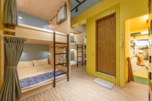 2 Etagenbetten in einem Zimmer mit einer Tür in der Unterkunft 山多香青年民宿 Santhosham Hostel in Sanxing Township