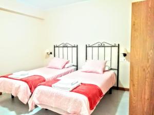 2 camas en una habitación con sábanas rosas y blancas en Apartamento Campillín, en Oviedo