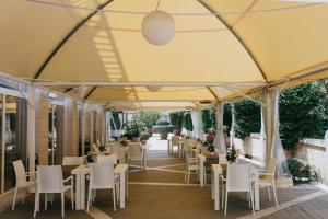 a restaurant with tables and chairs under a tent at Hotel Del Campo in Matera