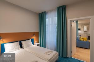 a bedroom with a large bed and green curtains at Dandelion Apartments Brīvības in Riga