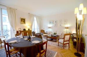 uma sala de jantar com uma mesa e uma sala de estar em Champs Elysees em Paris