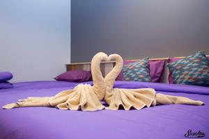 a towel sculpture of two swans on a bed at Green Two Resort in Chanthaburi