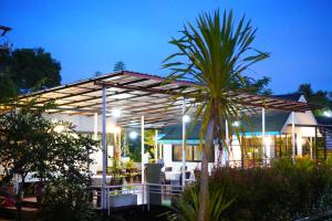 a house with a palm tree in front of it at Green Two Resort in Chanthaburi