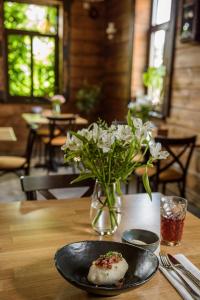 Noclegi Pod Sokołem في سوكولكه: طبق من الطعام على طاولة مع إناء من الزهور