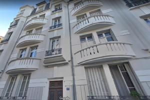 - un bâtiment blanc avec des balcons sur le côté dans l'établissement L Hôte Rutène, à Rodez