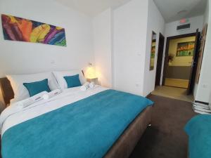 a bedroom with a large bed with a blue blanket at Wellness&Spa Hotel Astorya in Banja Luka +107 photos
