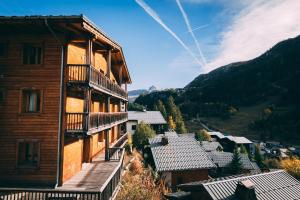 un grande edificio in legno con balcone in un villaggio di Chalet Rosko by Chalet Chardons a Tignes