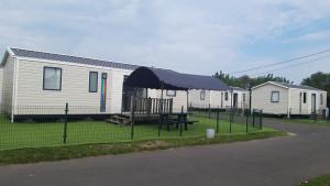 a picnic table in front of a mobile home at Chalet Park Zeeberm CommV in Oostduinkerke