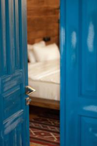 an open blue door with a bed in the background at Sazano Wine Cellar & Hotel in Sazano