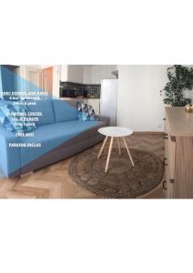 een woonkamer met een blauwe bank en een tafel bij Welcome au Dazzling Stay in Serris
