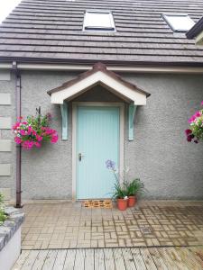 una casa con una puerta azul y algunas flores en The Loft at 522 en Woodburn