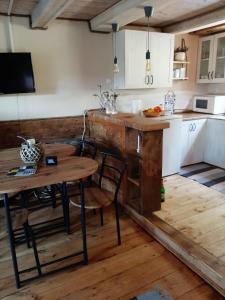 a kitchen with a wooden table and a table and chairs at Noclegi Siemianówka in Siemianówka