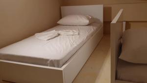 a small bed in a small room with white sheets at StelDi Luxury Apartments in Petalidi