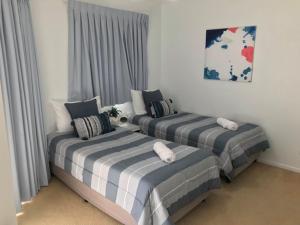 
a bed room with two beds and two lamps at Kings Way Apartments in Caloundra
