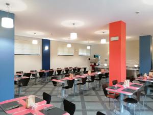 um restaurante com mesas e cadeiras num quarto em Open011 em Turim