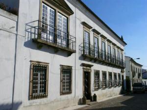 加維昂的住宿－Casa de Nossa Senhora da Conceição，白色的建筑,设有窗户和阳台,位于街道上