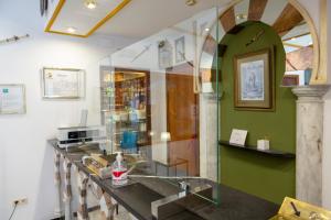 a glass counter in a room with a green wall at Los Omeyas in Córdoba