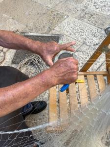 Un uomo che usa il prima possibile per tagliare un pezzo di legno di Porto Antico a Bari