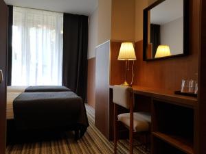 a hotel room with a bed and a mirror at Nėris Inn Terraces in Vilnius