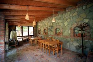 d'une salle à manger avec une table, des chaises et un mur en pierre. dans l'établissement Bucha`s Guest House & Wine Cellar, à Telavi