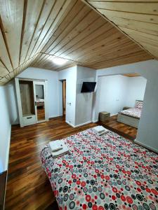 1 dormitorio con 1 cama con edredón rojo y negro en Enduro Transalpina en Obârşia Lotrului
