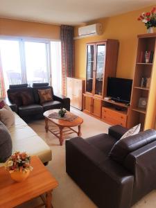 a living room with a couch and a tv at GEMELOS 22 APARTMENTS - Benidormland in Benidorm