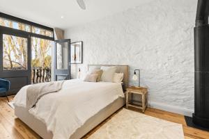 a bedroom with a bed and a white wall at TARALGA TERRACES The Whitings Store in Taralga