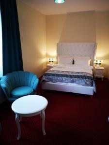 レグニツァにあるHotel i Restauracja Admirałのベッドルーム1室(ベッド1台、椅子、テーブル付)